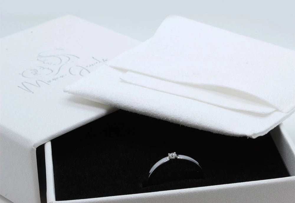 Elegante ring van 925 zilver met een sprankelende zirkonia, gepresenteerd in een luxe doos met een zachte doek.