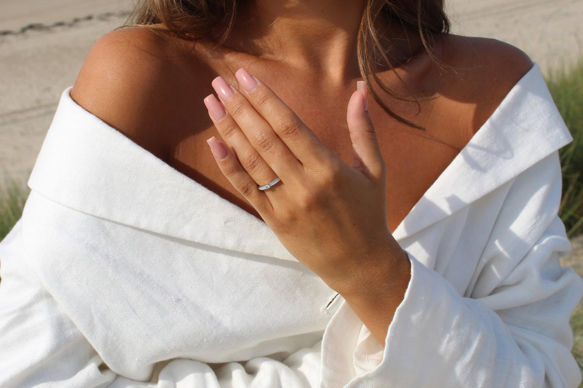 Elegante moedermelk-ring van 925 zilver met een subtiele, glanzende afwerking, gedragen door een persoon met een natuurlijke uitstraling.