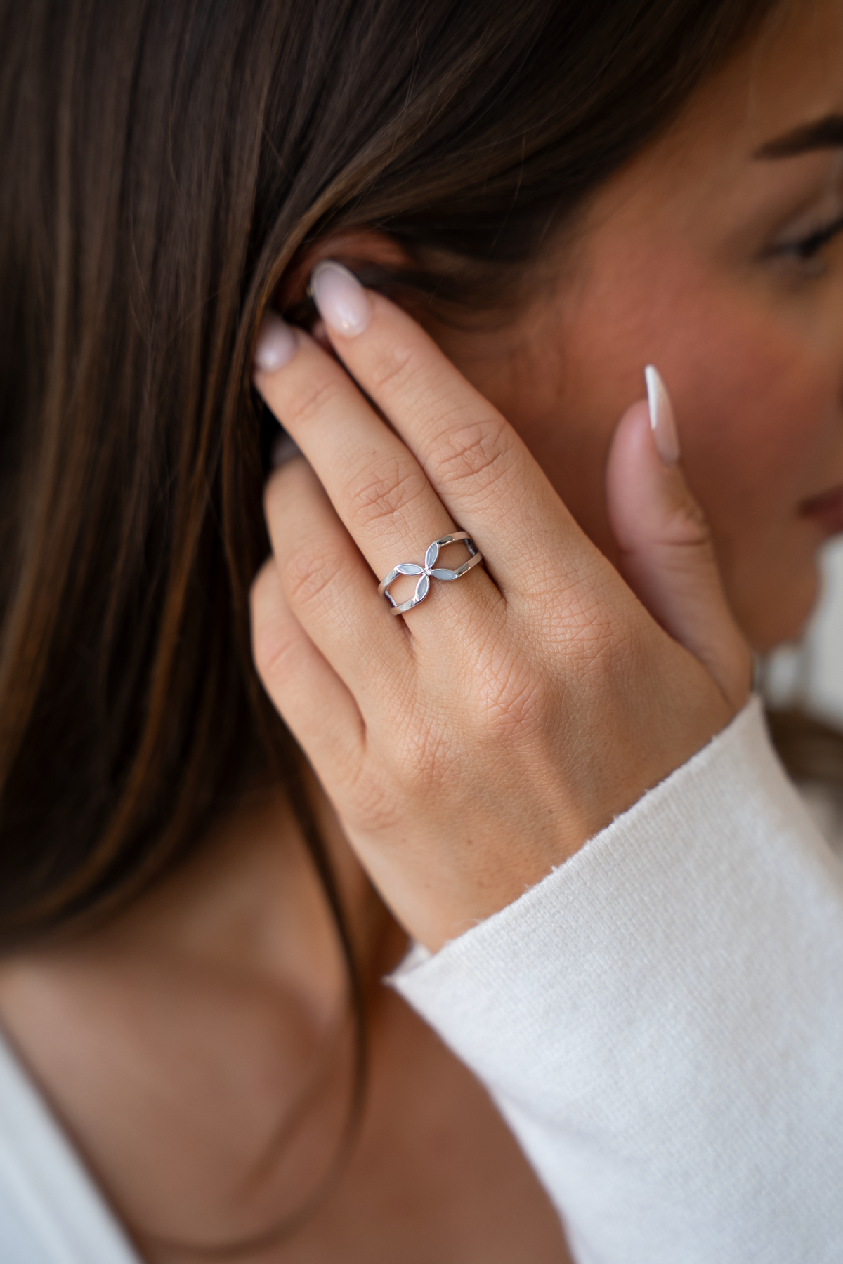 Moedermelk-ring van 925 zilver met een elegante, opengewerkte structuur, gedragen door een persoon met lange, natuurlijke nagels.