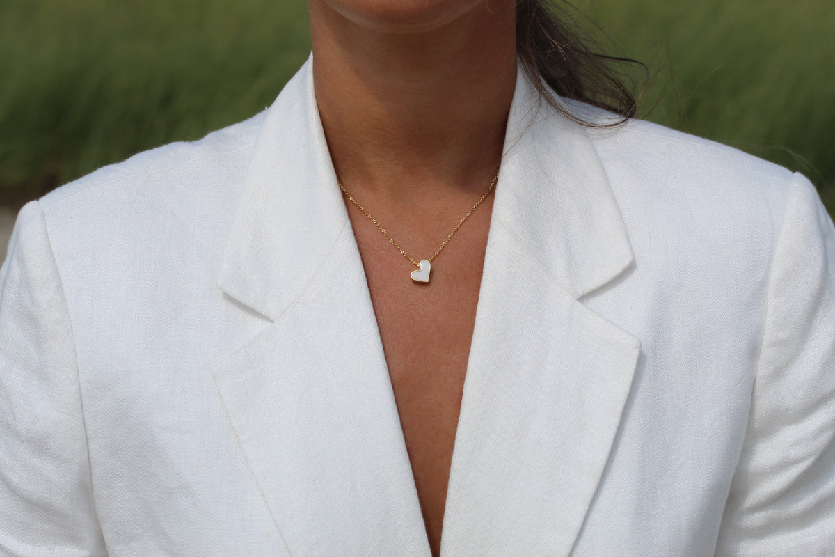 Hanger in de vorm van een hart van moedermelkhars, bevestigd aan een fijne ketting van 925 zilver.